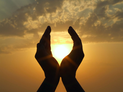 Picture of hands holding the sun at dawn