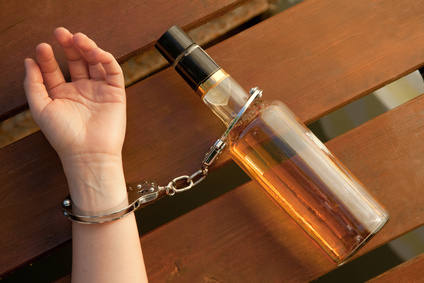 Bottle of alcohol handcuffed to a wrist